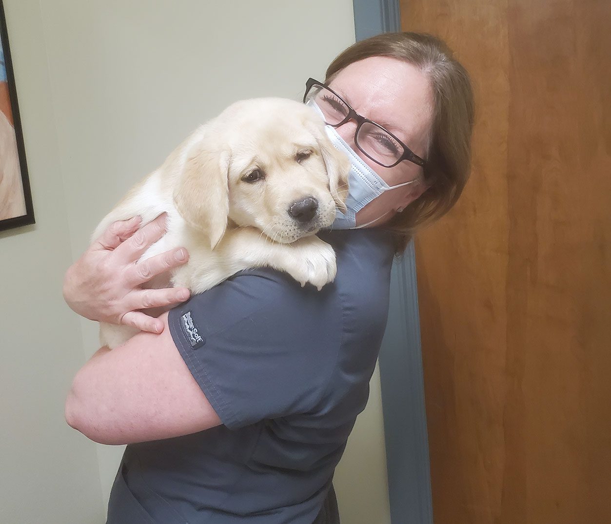 Female Veterinary Technician Holding Puppy